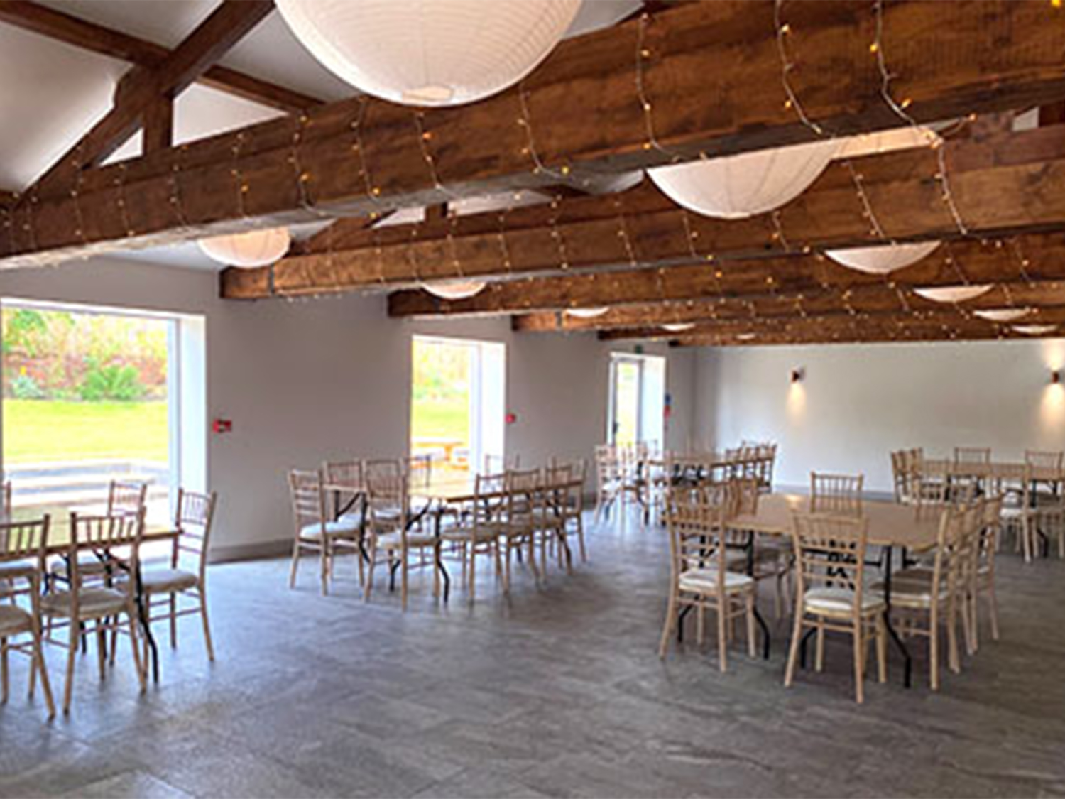 A light and airy room set up with several tables with chairs at Manor Oaks House.
