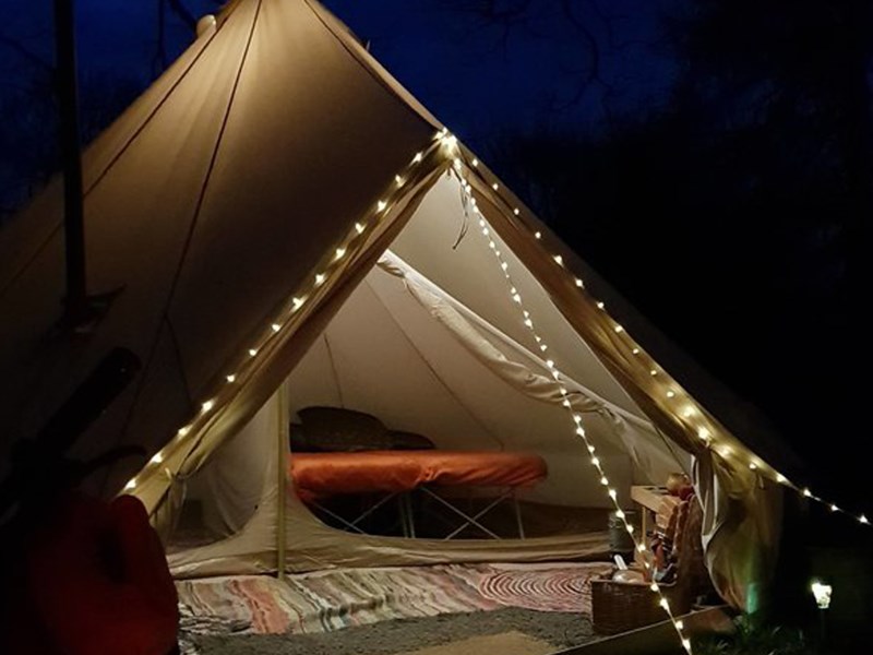 A tent lit up with a string of lights.