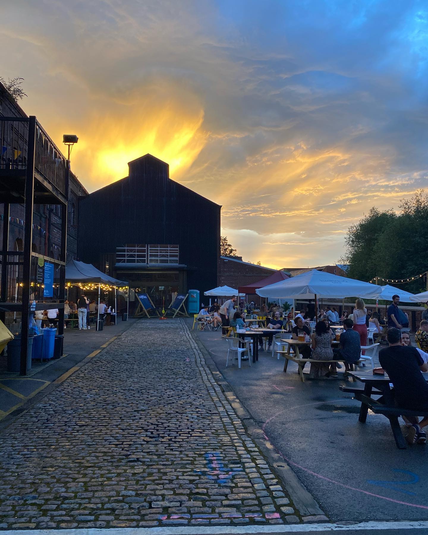 People drinking at dusk outside The Millowners Arms.