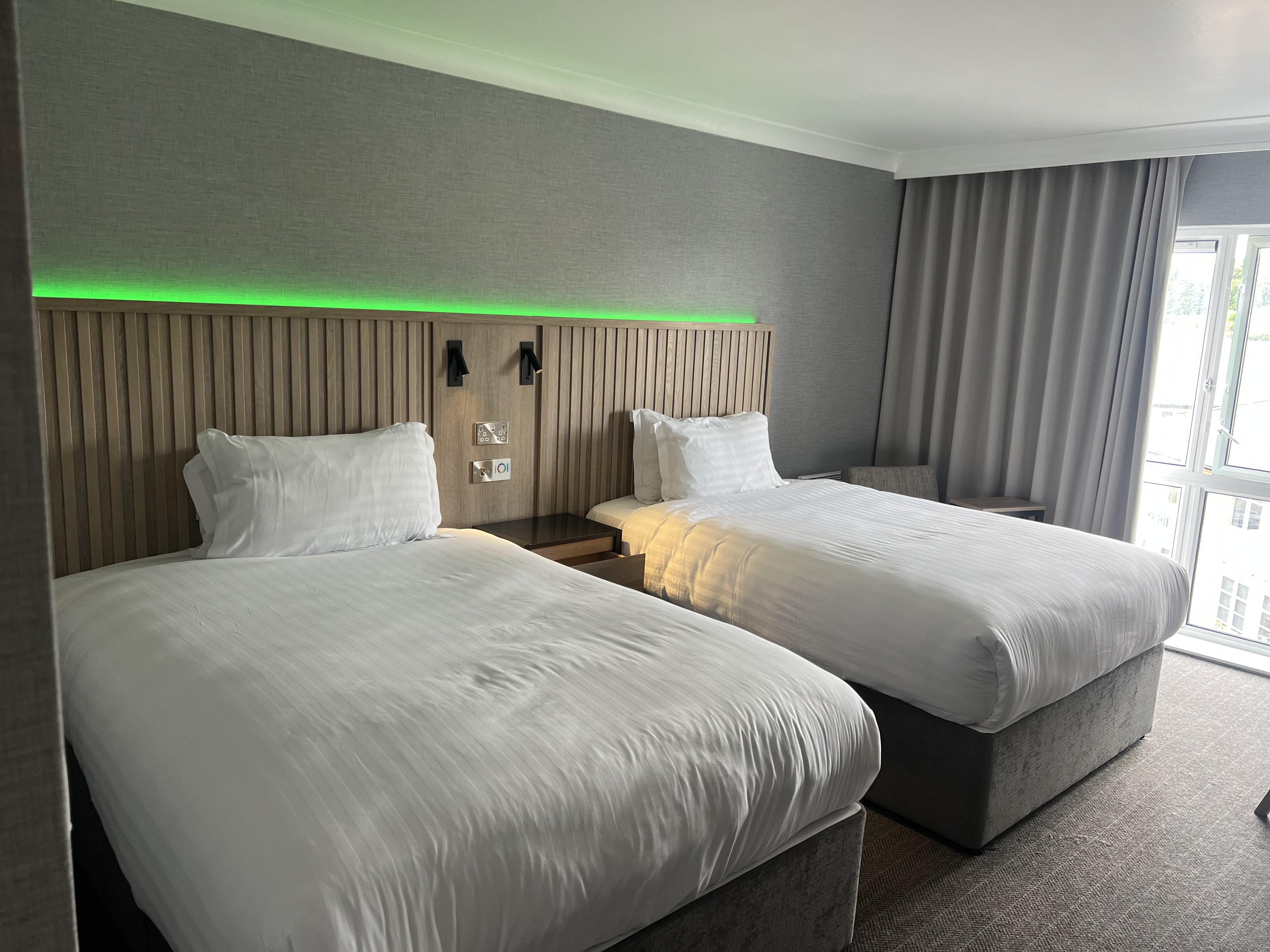 Modern bedroom with two single beds and ambient mood lighting