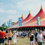 Crowds walk towards the bright red tent of the T'Other stage at Tramlines