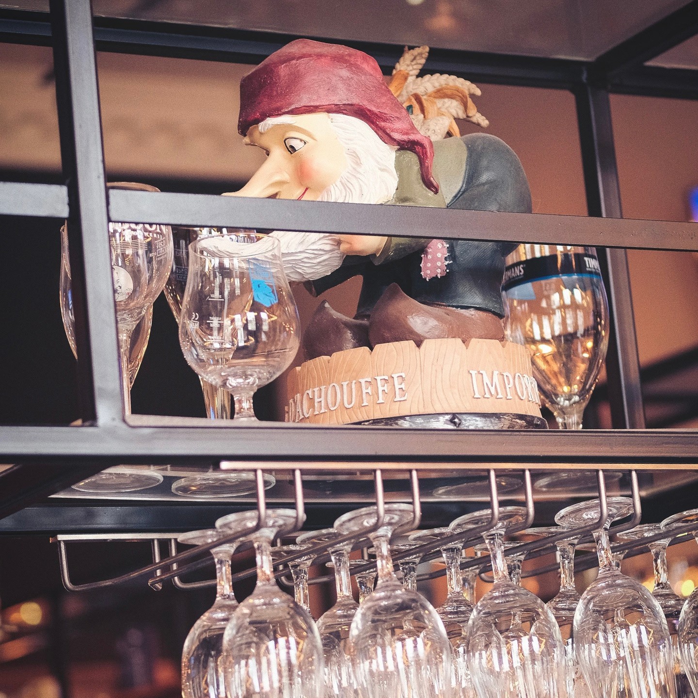 A model of a pirate hiding on am overhead glass rack, above the bar.