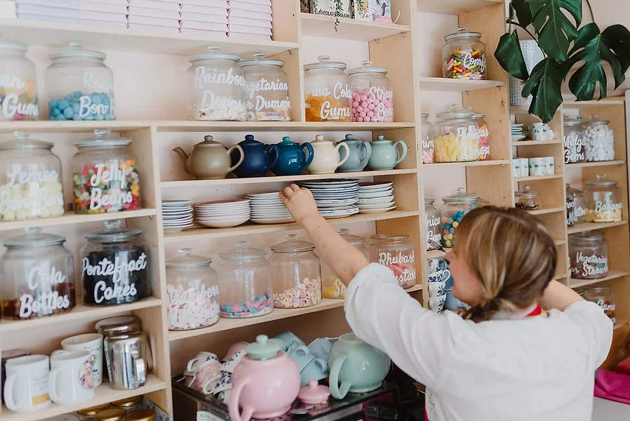 A woman stacking shelves with crockery at the Cocoa Wonderland shop.