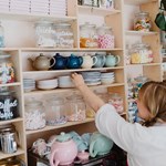 A woman stacking shelves with crockery at the Cocoa Wonderland shop.