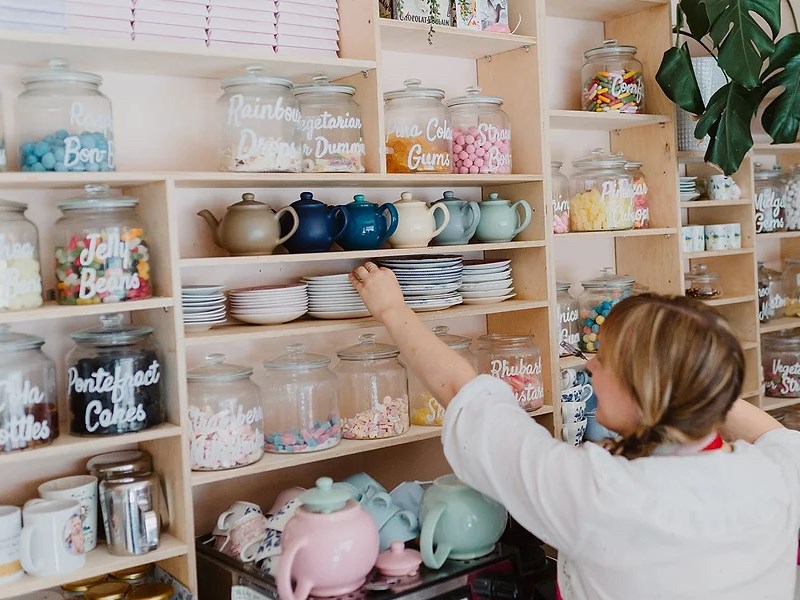 A woman stacking shelves with crockery at the Cocoa Wonderland shop.