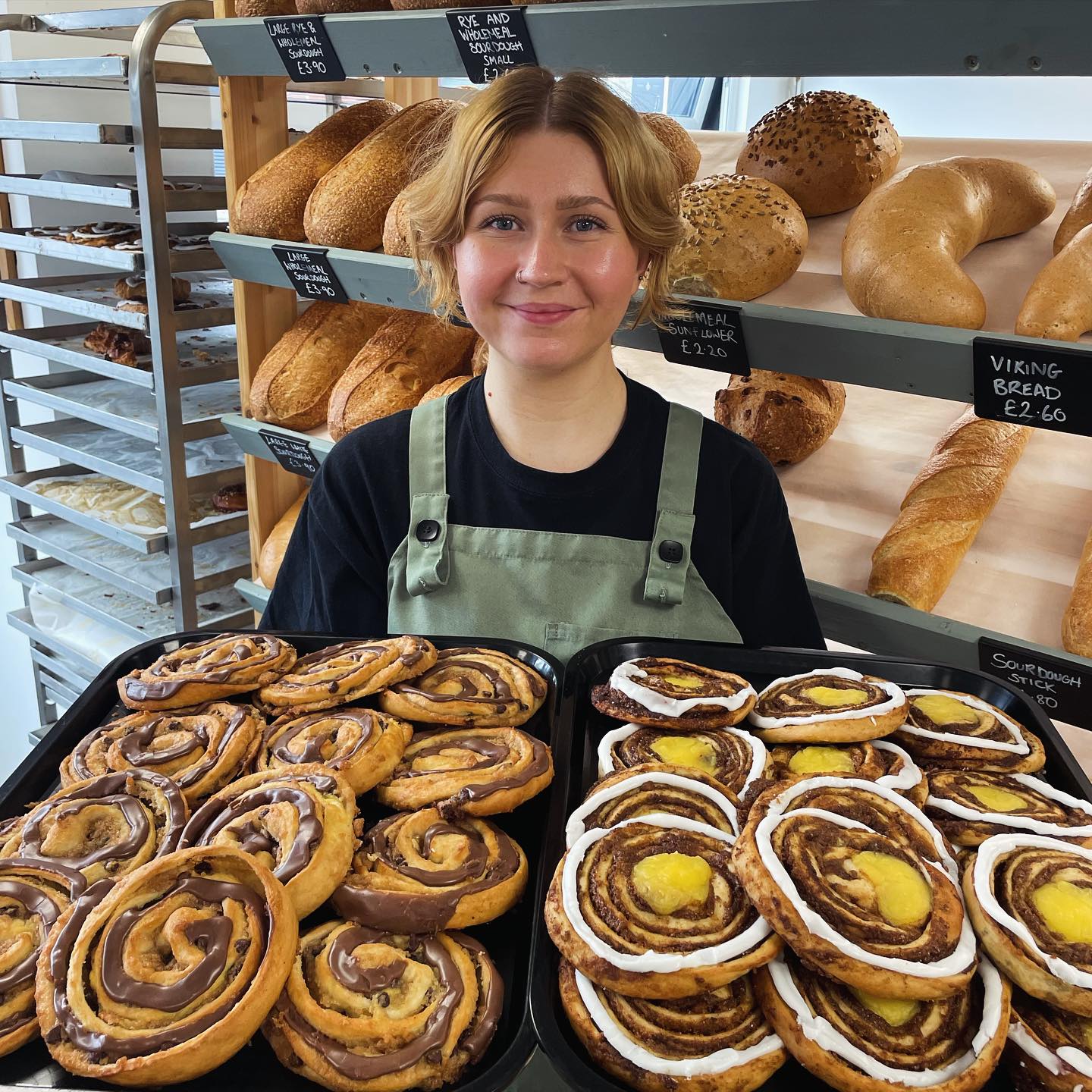 A woman holds a huge tray of pastries at Kringle Danish Bakery.