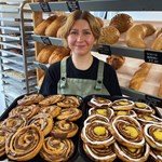 A woman holds a huge tray of pastries at Kringle Danish Bakery.