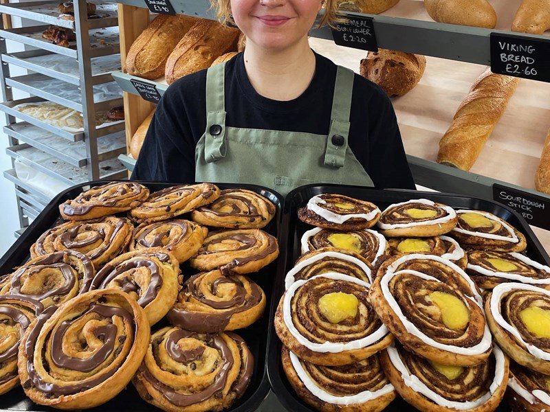 A woman holds a huge tray of pastries at Kringle Danish Bakery.