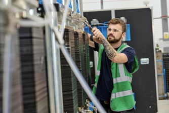 A man in a green high viz vest is working on a piece of machinery.