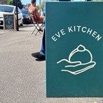 Blue sign with the words Eve Kitchen on it placed in the centre of the sign