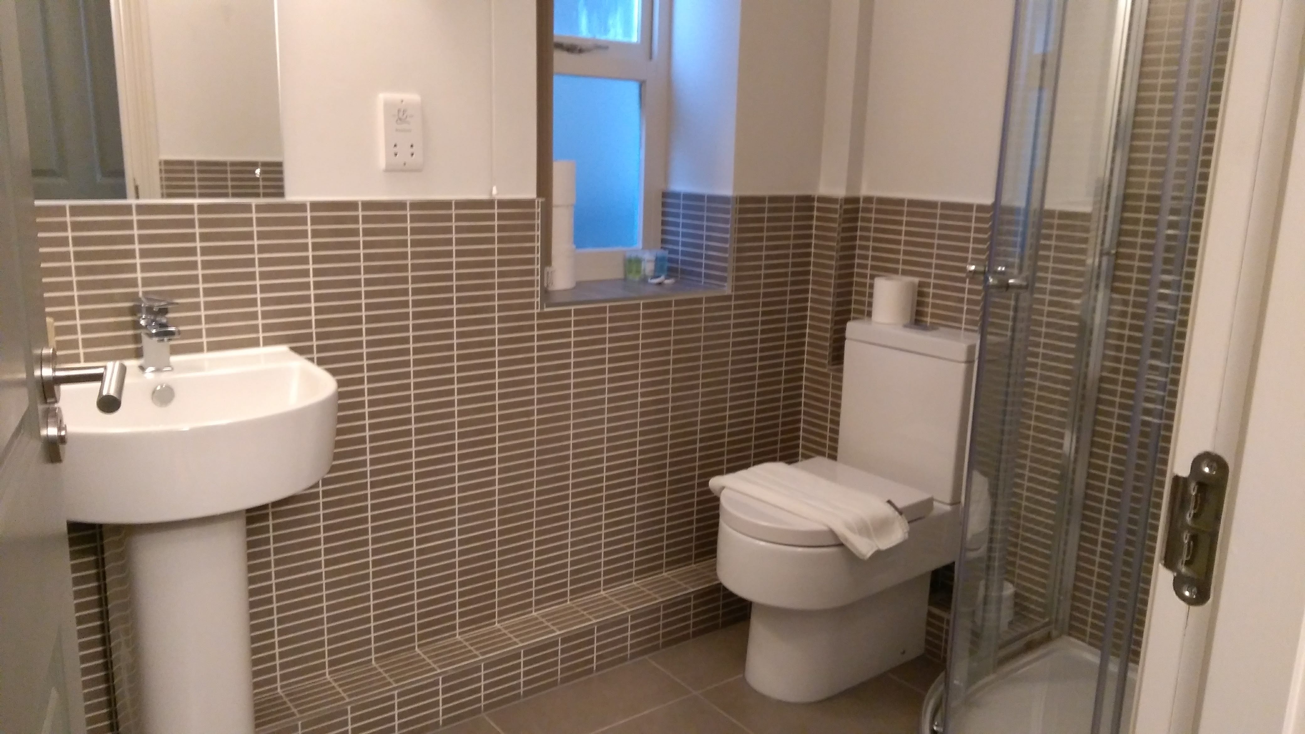 Homely Apartments – Figtree bathroom with walk-in shower, vanity, and modern fittings.