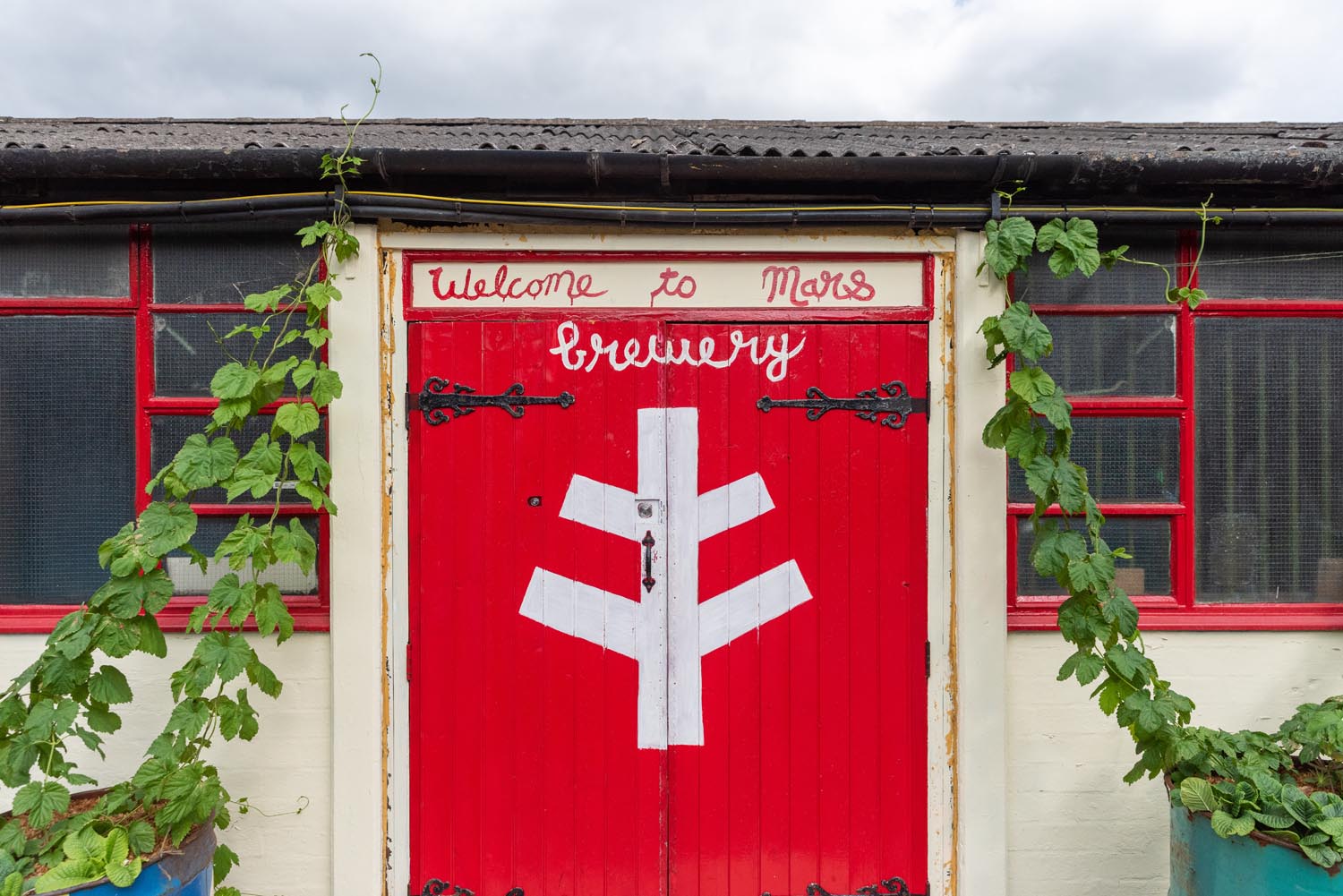 Bright red wooden double doors at The Brewery of St Mars of the Desert.