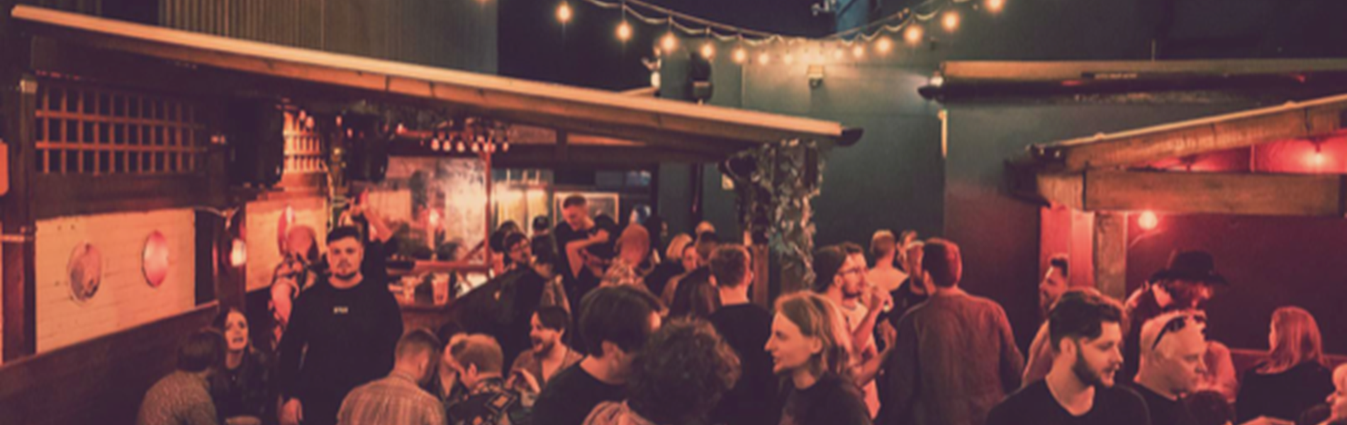 The beer garden at The Washington, filled with customers, at night.