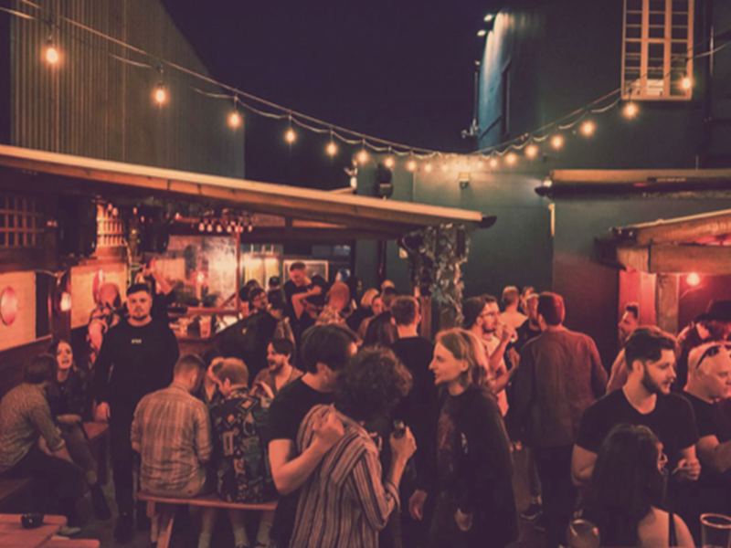 The beer garden at The Washington, filled with customers, at night.