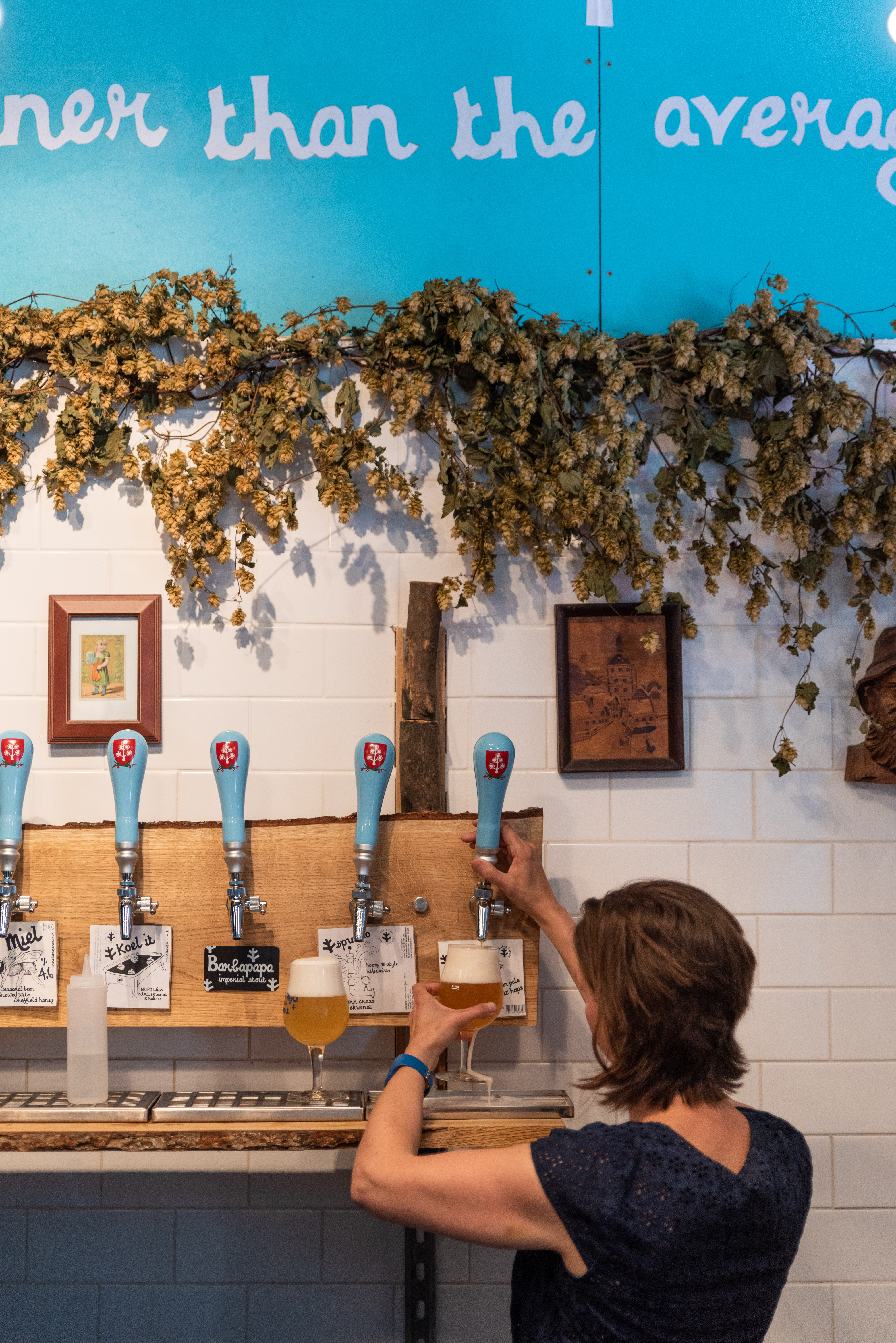 A woman pulling a pint at The Brewery of St Mars of the Desert.