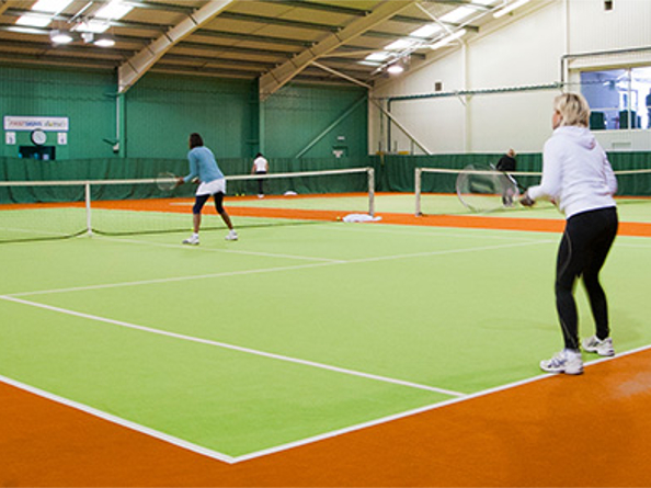People playing tennis on indoor courts at the Abbeydale Tennis Club.