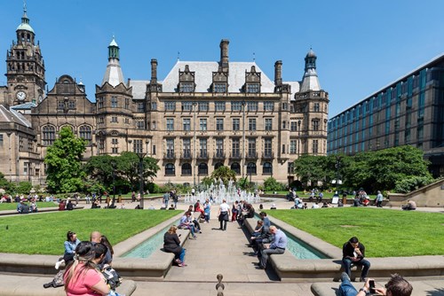 Crowds of people in the Peace Gardens on a sunny day in Sheffield.