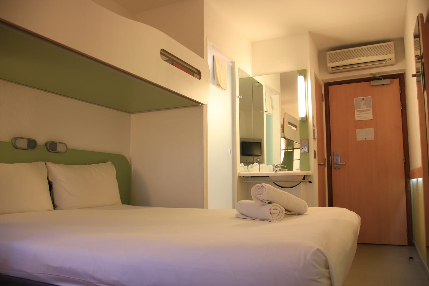 Interior of a bedroom featuring a double bed with a single bunk bed above and modern décor.