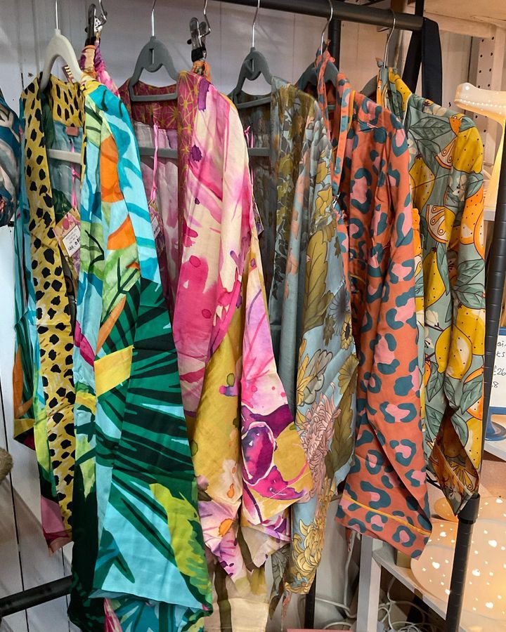 Colourful clothes hanging on a rail.