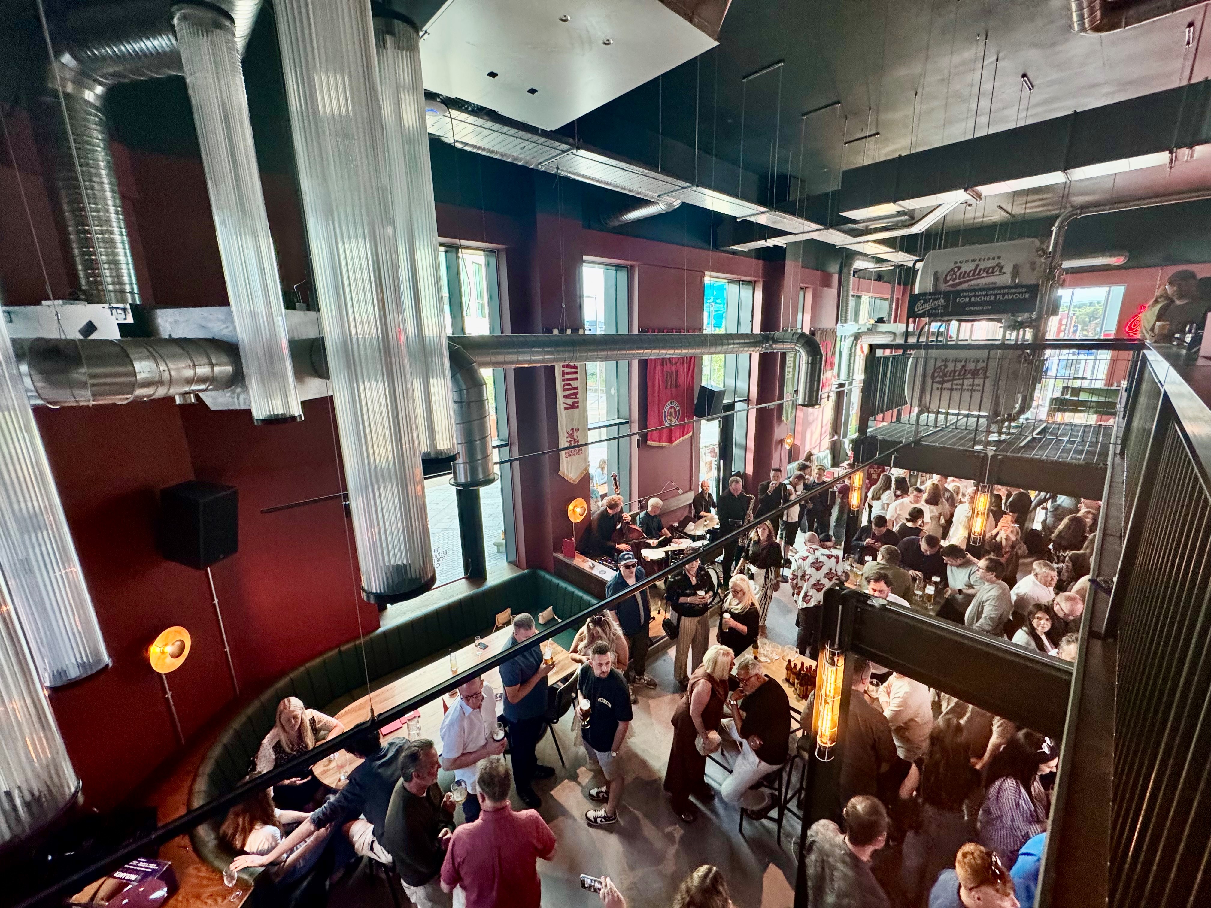 Looking down on lots of people drinking and socialising at Kapital Sheffield beer hall, from the upper floor balcony 