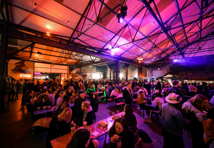 A view inside the Peddler market, there are lots of people seated at tables, eating and chatting.