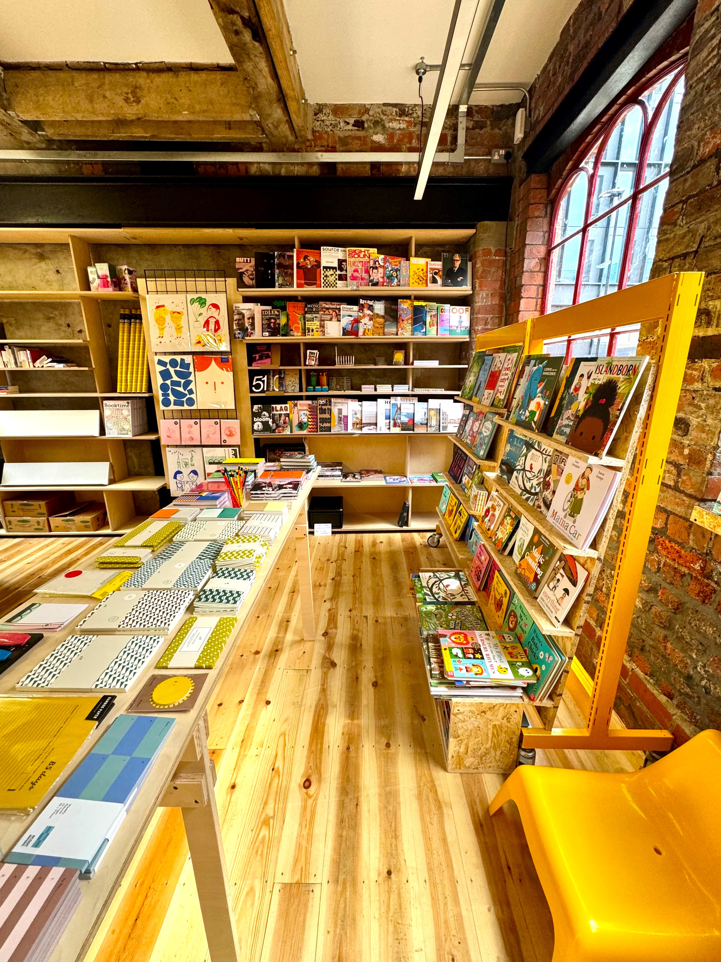 The interior of La Biblioteka bookshop, with all the walls lined with wooden shelves filled with books for sale.
