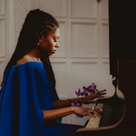 Isata Kanneh-Mason sitting at a piano, playing.