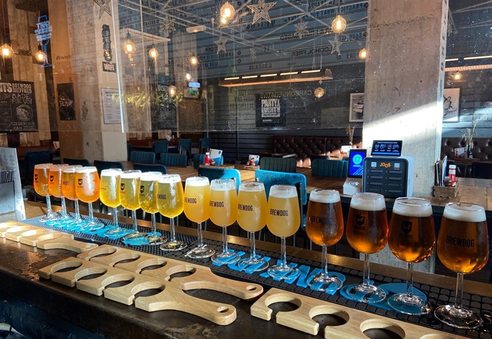 A counter with a long row of glasses of beer.
