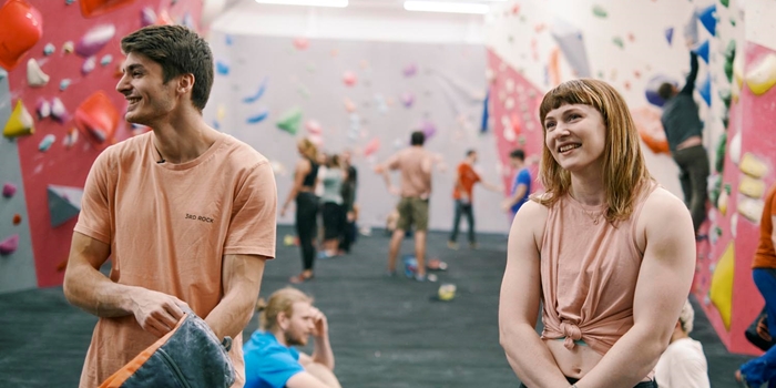 People having fun at an indoors climbing wall.