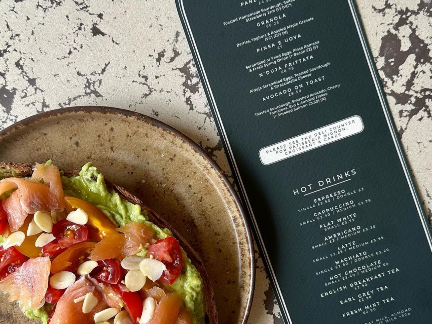 A salad on a table next to La Bottega's menu. 