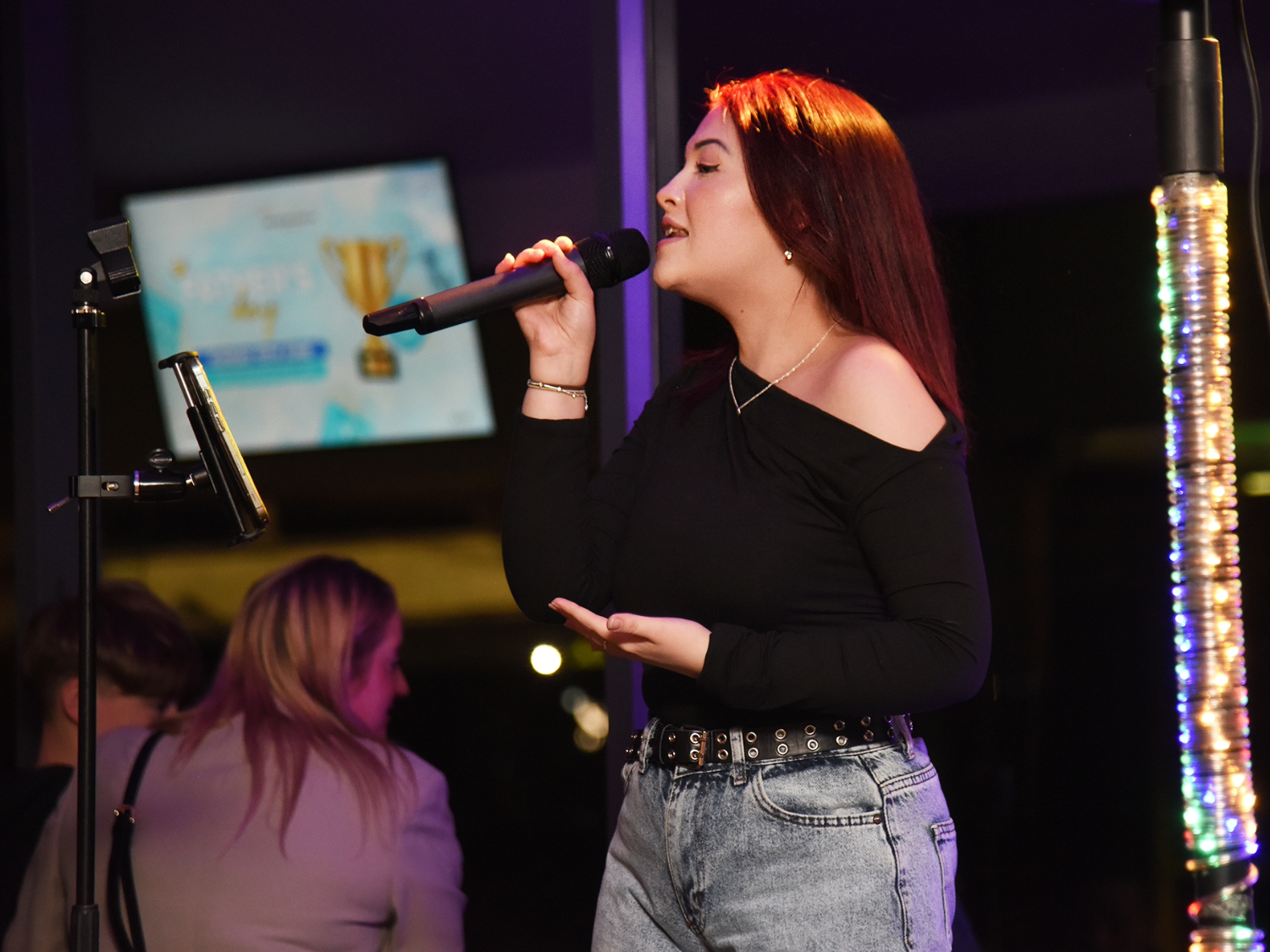 A woman sings into a microphone.