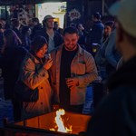 Crowds in the outside courtyard at Peddler Market, warming themselves around a fire pit while sipping drinks.