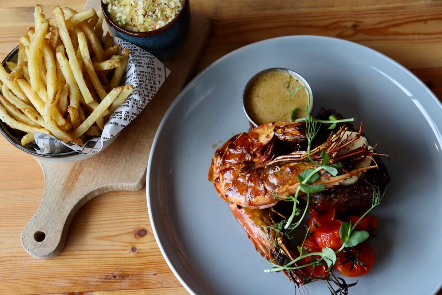 Prawns on a plate with a bowl of french fries at Butcher & Catch.