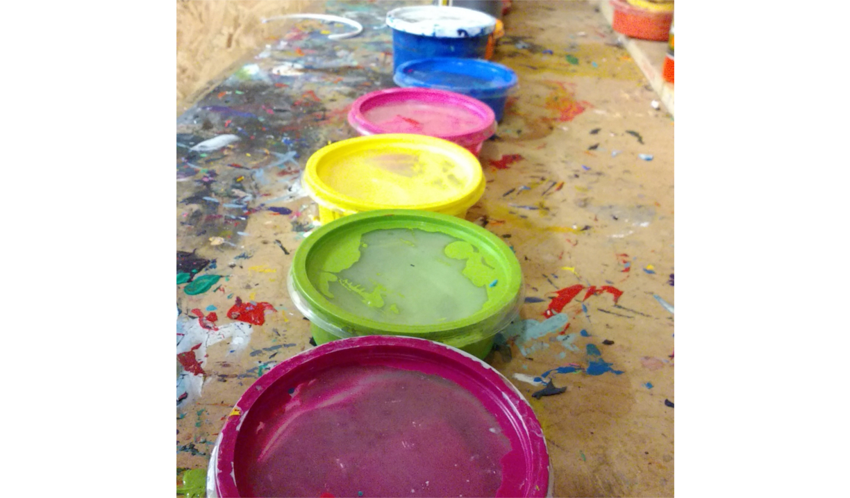 Six pots of screen printing ink.