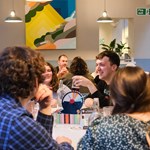 Tables at The Treehouse Cafe, filled with people enjoying drinks and playing board games.