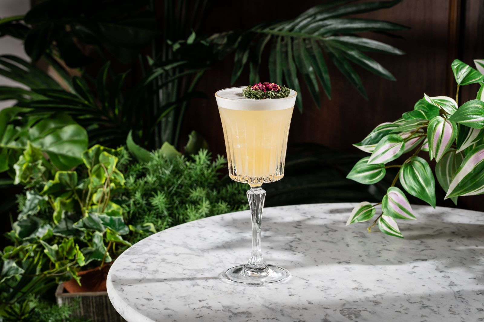 A cocktail sits on a round marble table.