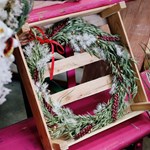 A wooden box with a festive wreath in.