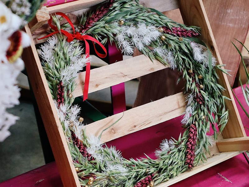 A wooden box with a festive wreath in.