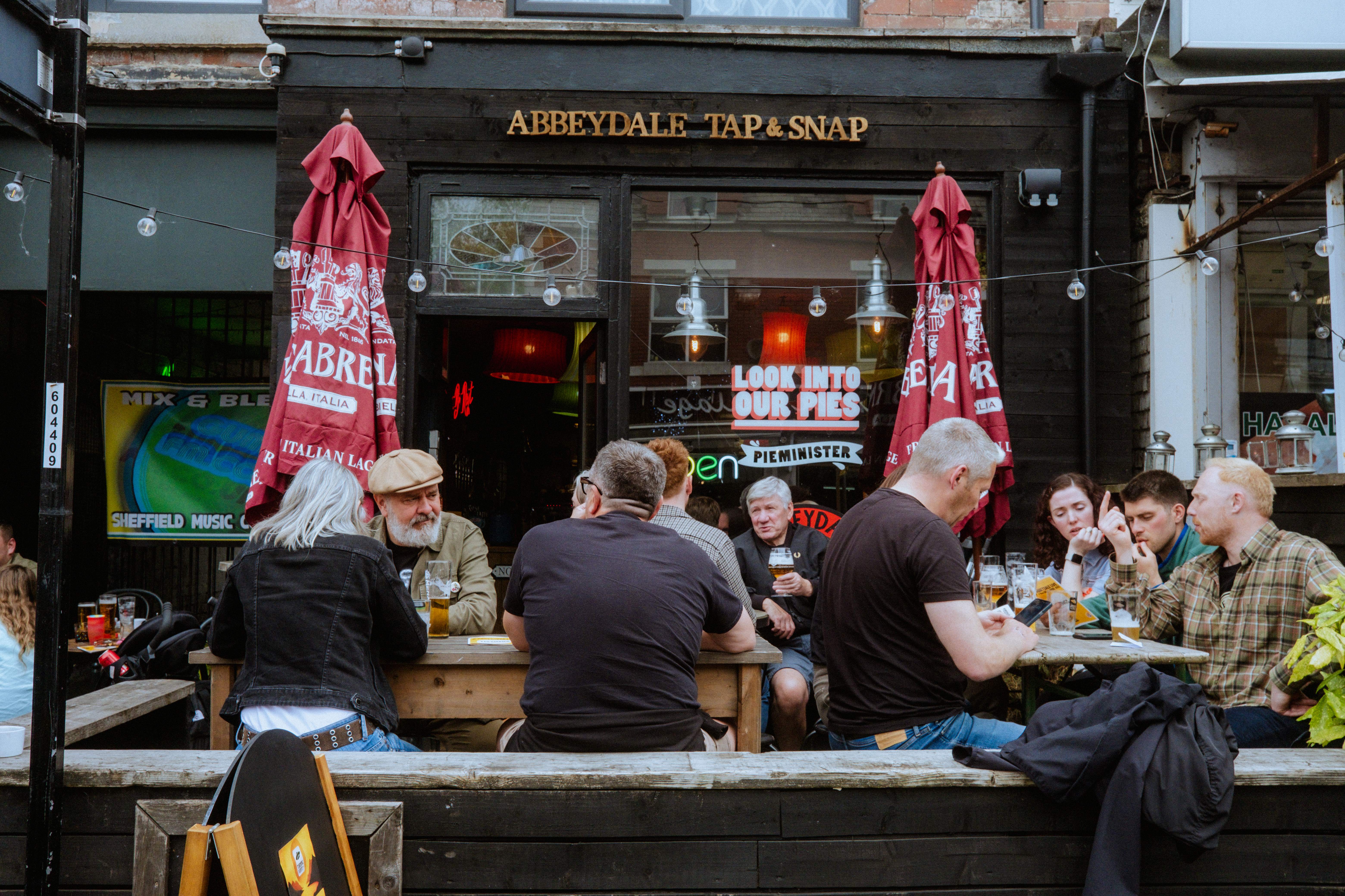 Groups of people sat drinking outside The Abbeydale Tap 