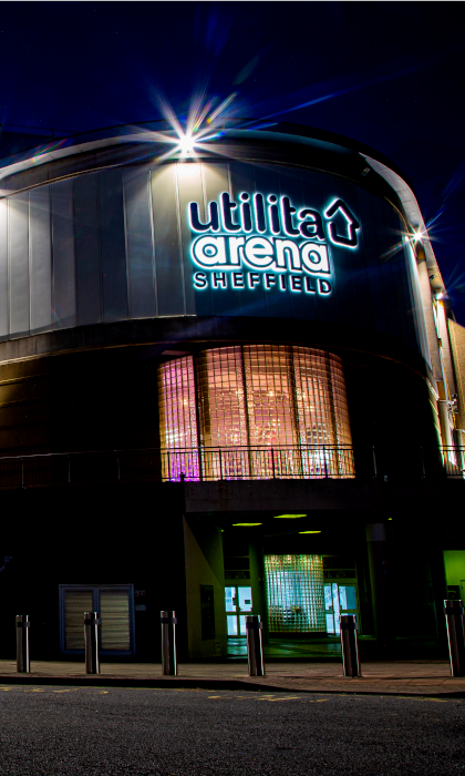 The Utilita Arena Sheffield lit up at night.