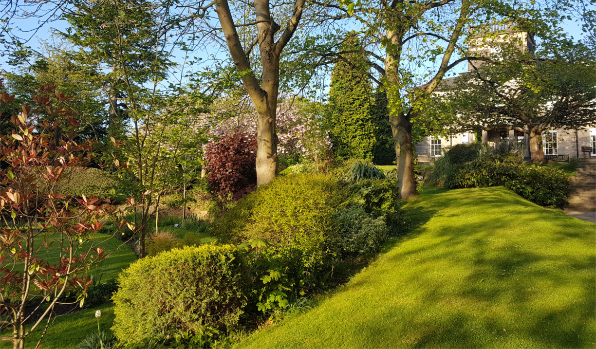 Beautiful landscaped grounds surrounding Halifax Hall Hotel with trees and gardens.