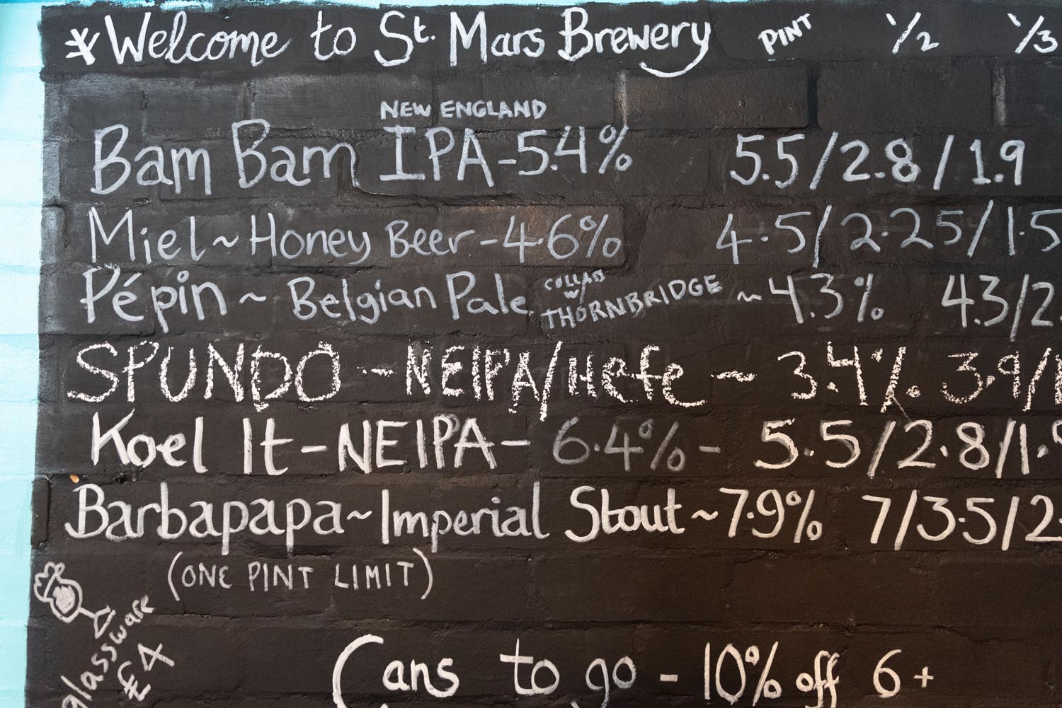 A hand written board with beer names and prices at The Brewery of St Mars of the Desert.