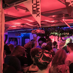 A crowded night club full of people dancing.