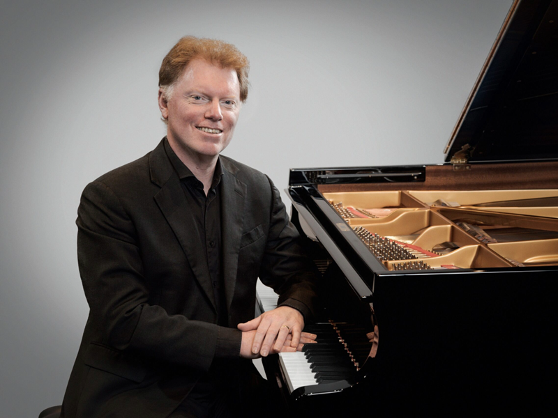 Tim Horton sat at a grand piano.