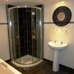 shower room with a walk-in shower and sink, featuring clean and modern fixtures.